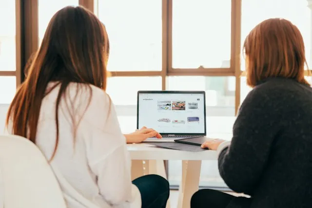 deux femmes travaillent ensemble sur un ordinateur