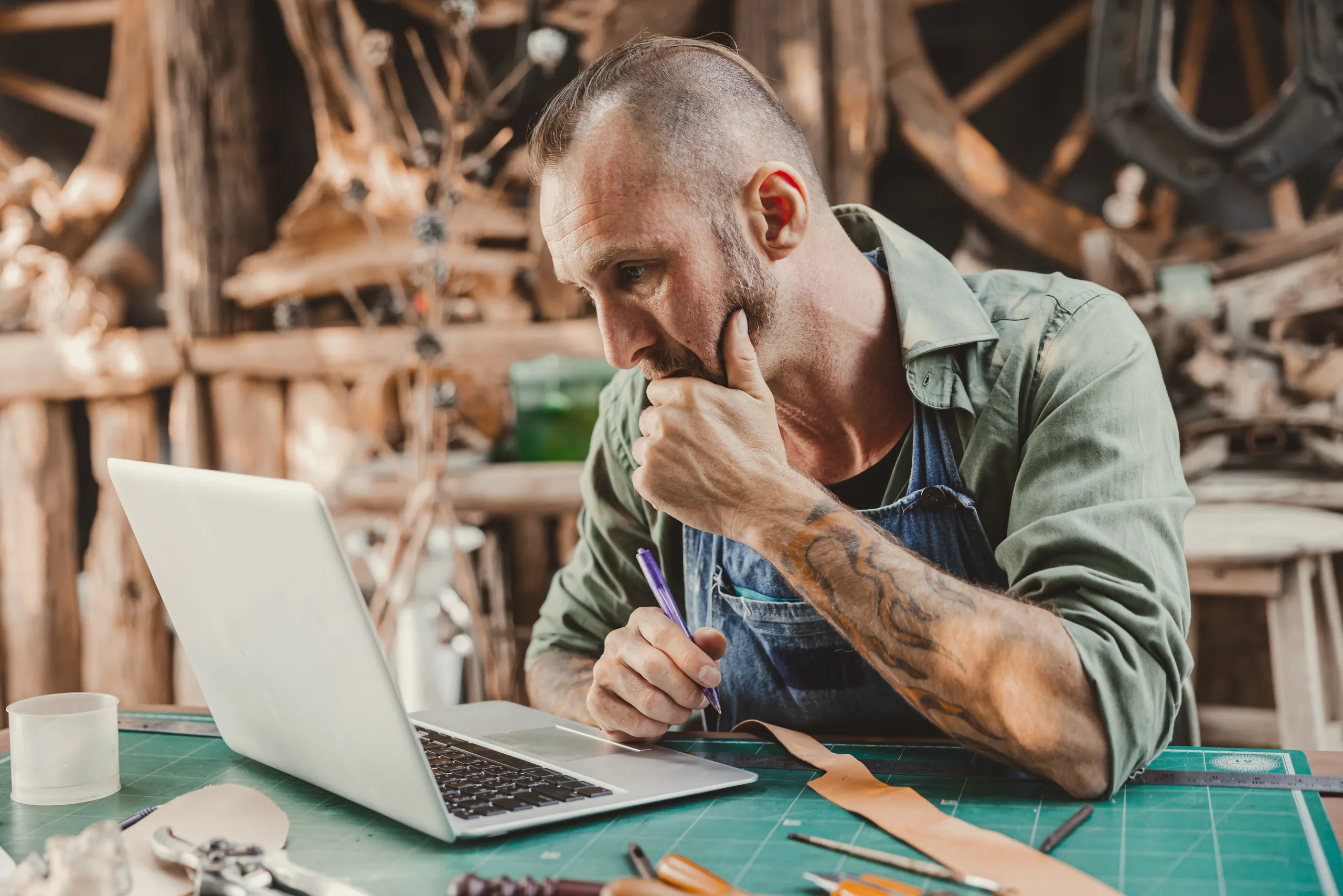 Un artisan dans son atelier qui est sur son ordinateur portable